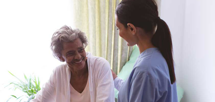 nurse helping a woman in elder years