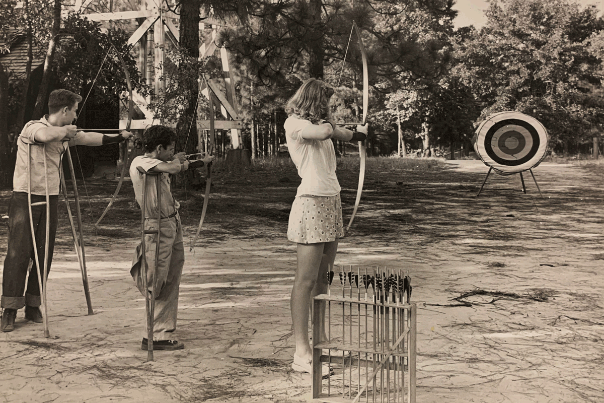 Slideshow of old film photos of campers doing archery, swimming, and painting on a car